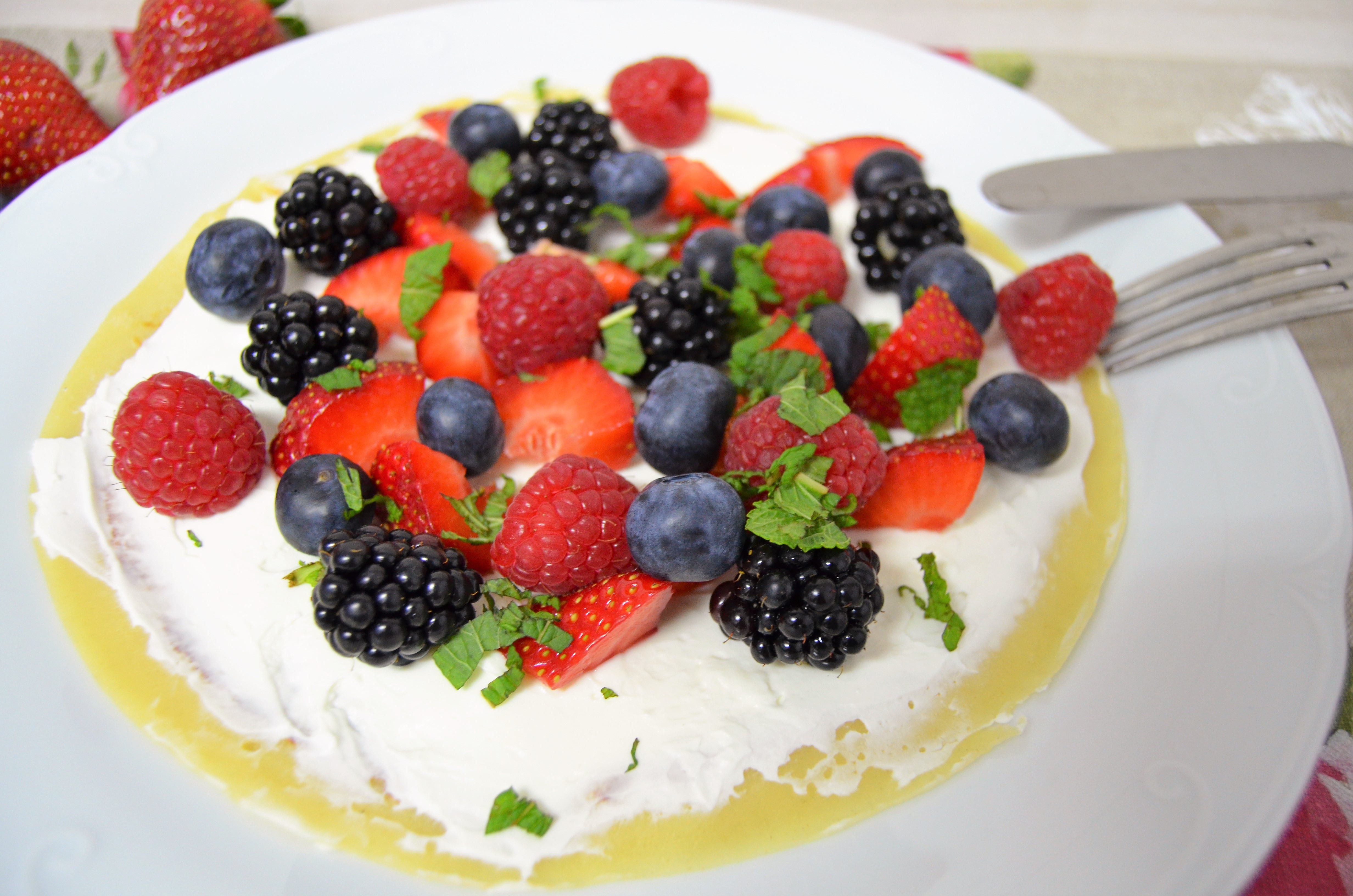 Tarta de yogur y frutos rojos con decoración de flores y frutos rojos